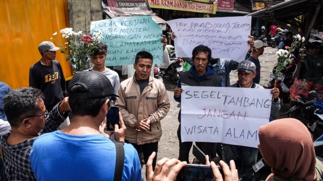 Massa membawa spanduk bertuliskan “Segel Tambang, Bukan Wisata Alam".